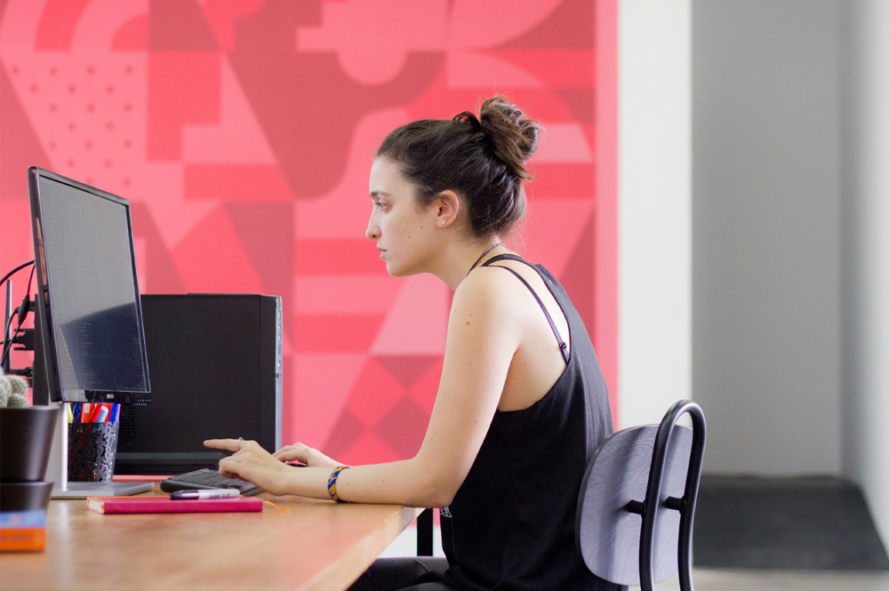 Woman sitting at an office desk with poor posture